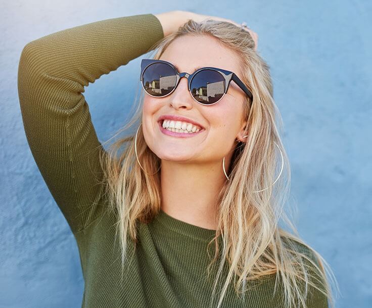 a woman wearing sunglasses smiling