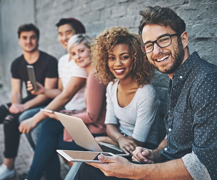 a group of young adults using a variety of devices