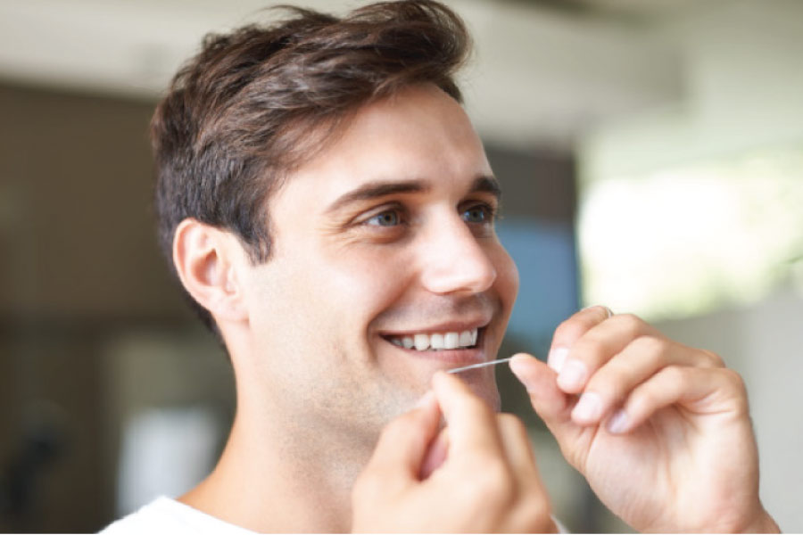 man gets ready to floss his teeth