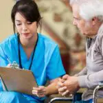 senior man participates in a dental implants initial consultation with a female dentist