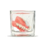 dentures soaking in water with cleaning tablet to help them stay well maintained how long do dentures last