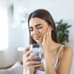 woman with sensitive teeth, drinking ice water, teeth sensitivity
