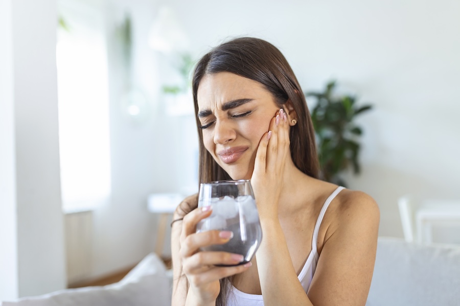 woman with sensitive teeth, drinking ice water, teeth sensitivity